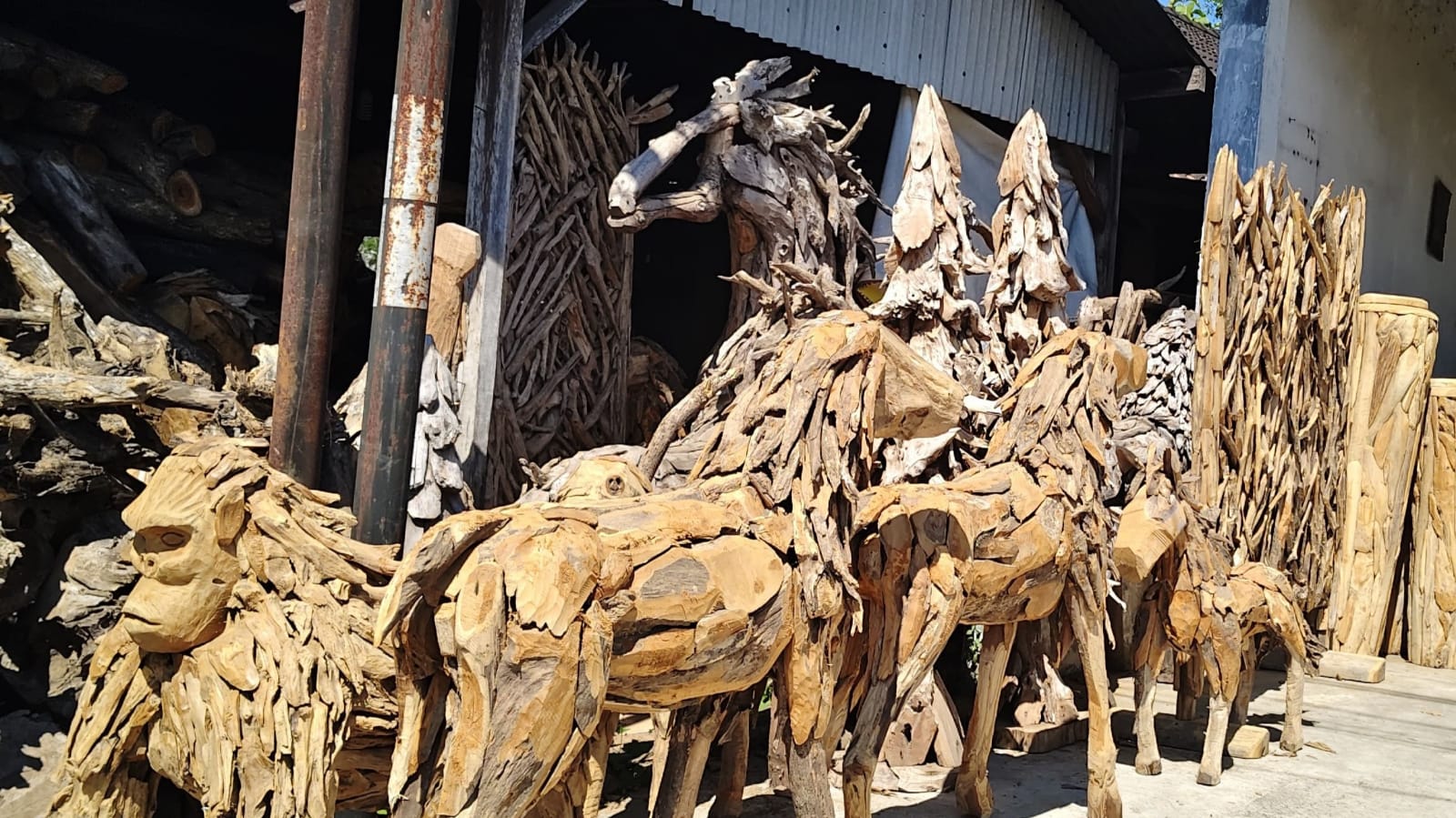 Indonesian artisans crafting teak root animal sculptures